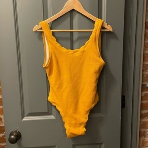 Mustard yellow. Scalloped edges. Size Small one piece swimsuit.